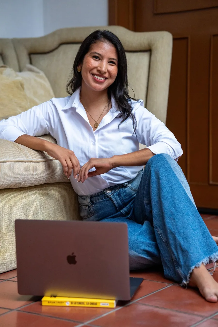 La psicóloga Johana Ortiz sonriendo, sentada con su portátil