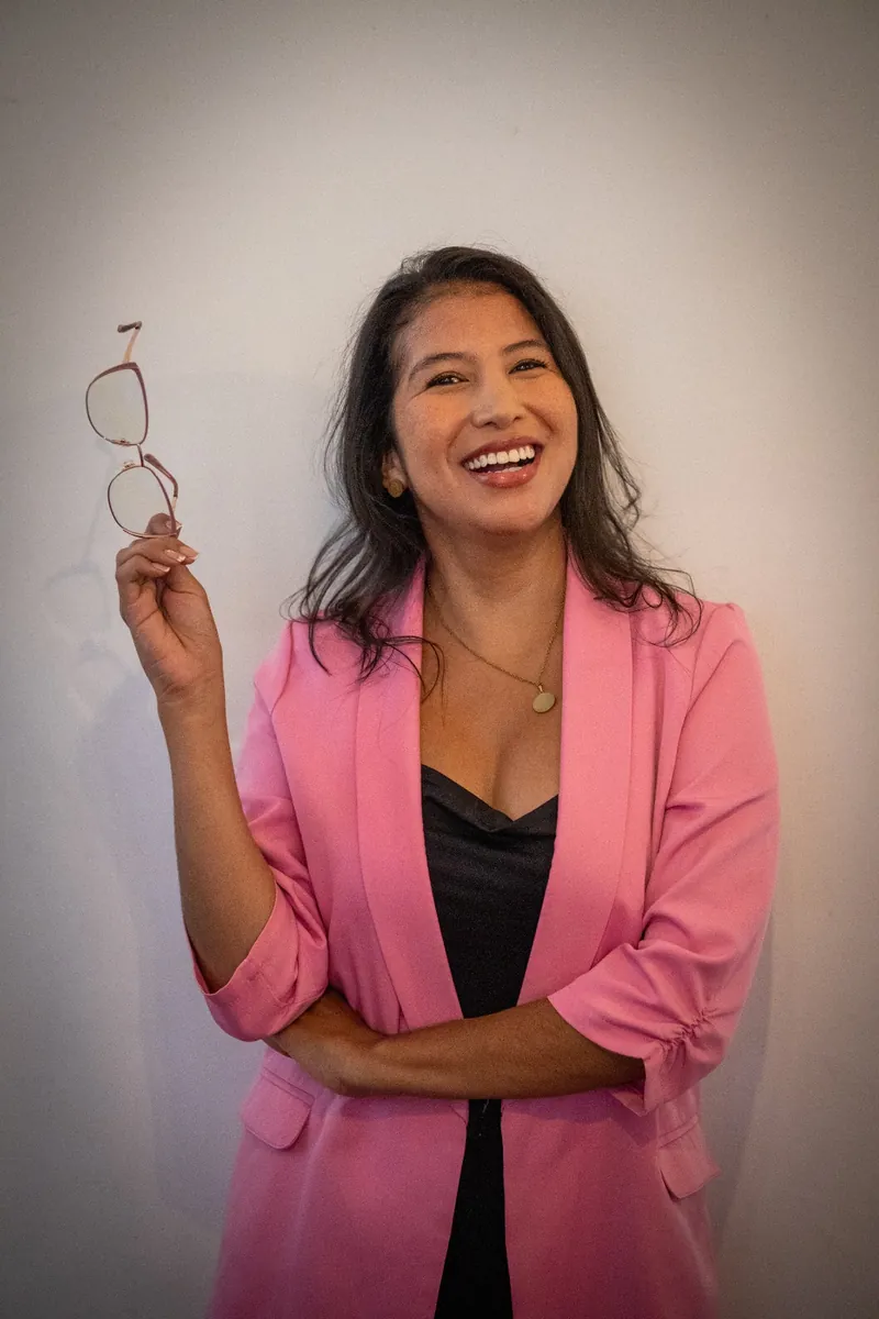 La psicóloga Johana Ortiz sonriendo junto a un libro abierto